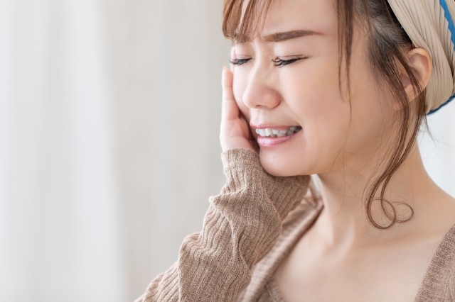 歯の痛みを感じる女性
