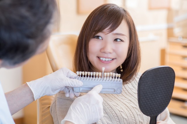 歯を見せて色見本を確認する女性